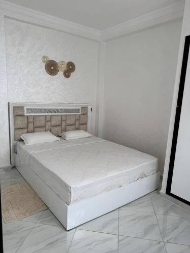 a white bedroom with a large bed in a room at Mini Villa Al Hoceima in Al Hoceïma
