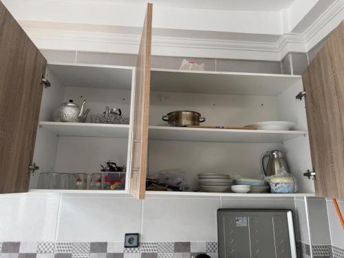 a kitchen with a cupboard filled with lots of dishes at Mini Villa Al Hoceima in Al Hoceïma