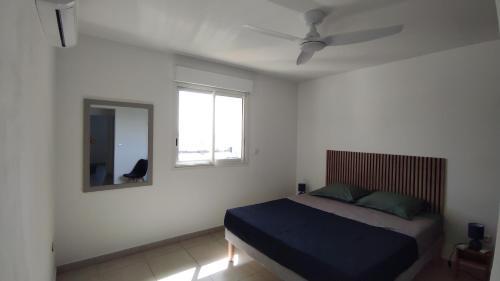 a bedroom with a bed and a mirror at L'Îlot de la Marina in Le Marin