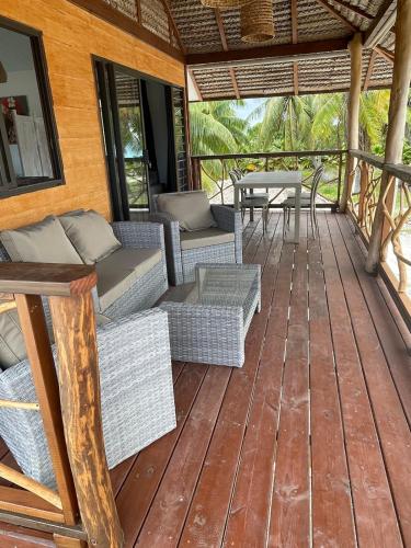 un ponte con divani, tavoli e un tavolo di Fareana Lodge Bungalow Piti a Fakarava