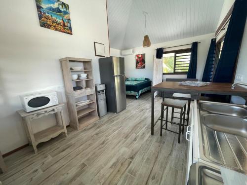 una cucina e un soggiorno con un tavolo e un frigorifero di Fareana Lodge Bungalow Piti a Fakarava