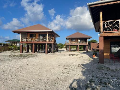 a couple of houses sitting on top of a dirt field at Fareana Lodge Bungalow Piti in Fakarava