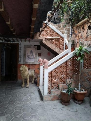 a white tiger standing next to a staircase at Hostal Refugio in Sanctórum