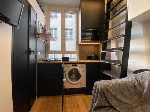 une buanderie avec une machine à laver et une fenêtre dans l'établissement Studio au cœur de paris, à Paris