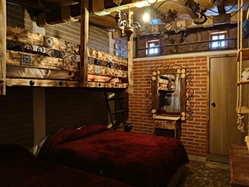 a bedroom with a red bed and a mirror at Hostal Refugio in Sanctórum