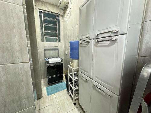 a small kitchen with a refrigerator and a window at Apto na beira da praia do Centro | ROMM207 in Rio das Ostras