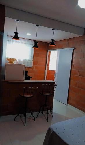 a room with two chairs and a bar with a window at "Refúgio Lima" in São Sebastião