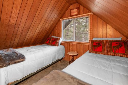 1 Schlafzimmer mit 2 Betten in einer Holzhütte in der Unterkunft Little Red Cabin with a Hot Tub BBQ plus large Yard in Sugarloaf