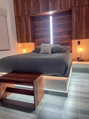 a bedroom with a large bed with a wooden headboard at Love us in Tequisquiapan
