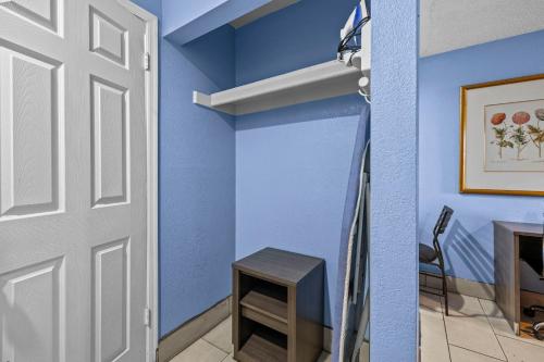 a room with blue walls and a door and a table at American Executive Inn Mesa in Mesa