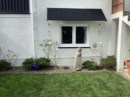 a garden with a statue in front of a house at Tranquille in Tauranga in Tauranga