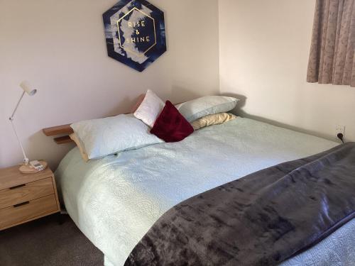 a bedroom with a bed and a clock on the wall at Tranquille in Tauranga in Tauranga
