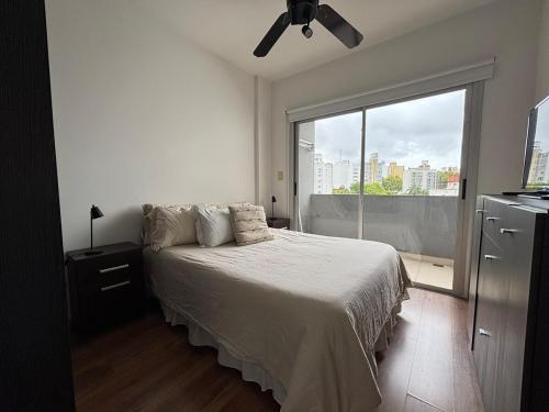 Un dormitorio con una cama y una ventana grande en Praga, amplio y luminoso, en La Plata