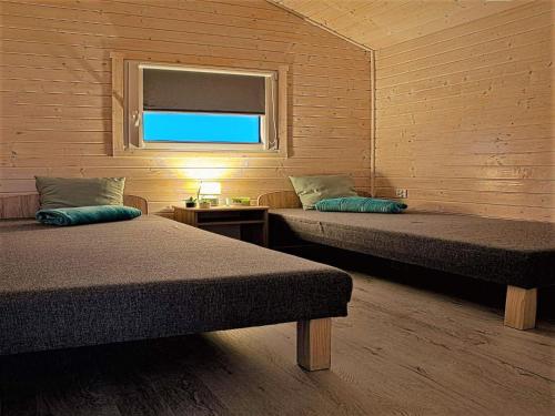 une chambre avec deux lits et une fenêtre dans l'établissement Holiday Home in Dziwnówek by Baltic Sea, à Dziwnówek