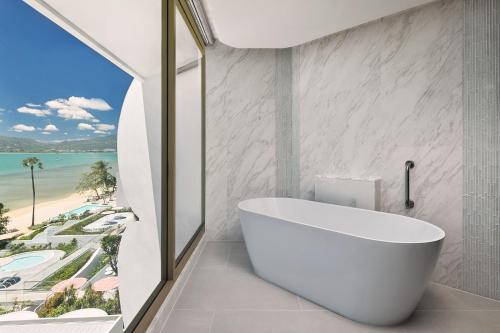 a bathroom with a tub and a view of the beach at Veranda Resort Phuket, Autograph Collection in Panwa Beach
