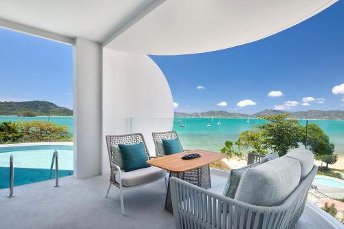 a patio with a table and chairs and a view of the ocean at Veranda Resort Phuket, Autograph Collection in Panwa Beach