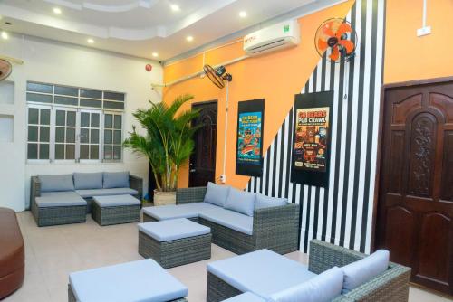 a lobby with couches and tables in a building at Happy Bear Hostel Phu Quoc in Phu Quoc