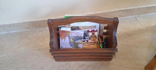 ein mit Büchern gefüllter Holzbehälter auf dem Boden in der Unterkunft Casa na Martim de Sá in Caraguatatuba