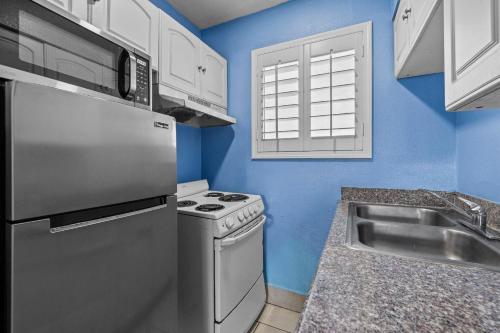 a kitchen with a refrigerator and a sink at American Executive Inn Mesa in Mesa