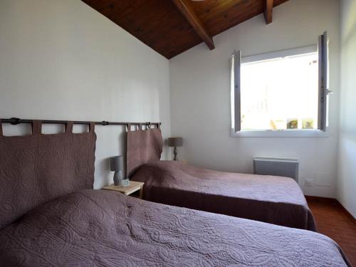 une chambre avec deux lits et une fenêtre dans l'établissement Villa moderne 4 pièces, 6 pers, proche mer, WIFI, animaux OK, parking - FR-1-705-13, à La Palmyre
