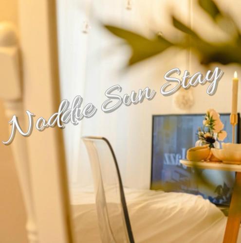 首尔Noddle Sun Stay的一张桌子和一张睡床,上面写着一个读出变数太阳的标志