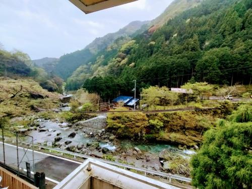 a view from a balcony of a river and mountains at 山村自然楽校しもなの郷 in Nanokawado