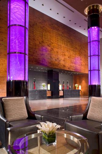 a lobby with chairs and a bar with purple lighting at Grand Millennium Beijing in Beijing