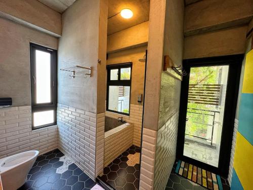 a bathroom with a tub and a toilet and a window at Hillside Beautiful House in Taitung City