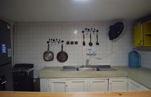 a kitchen with a sink and utensils on the wall at Hostel SOLUNA Operador Turístico y Hotelero in Ríohacha