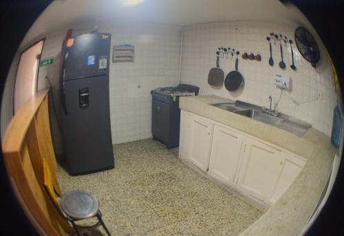 a small kitchen with a sink and a refrigerator at Hostel SOLUNA Operador Turístico y Hotelero in Ríohacha