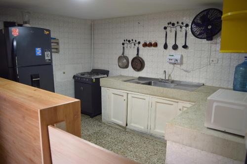 a kitchen with a sink and a refrigerator at Hostel SOLUNA Operador Turístico y Hotelero in Ríohacha