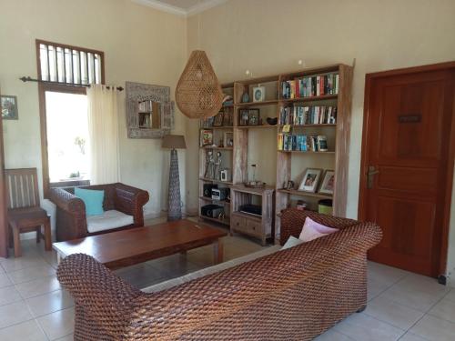 a living room with a table and chairs and a book shelf at Guesthouse Rumah Senang in Kalibaru