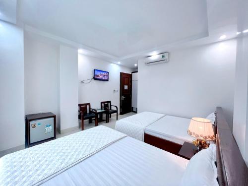 a hotel room with two beds and a tv at Đức Thắng Hotel in Sầm Sơn