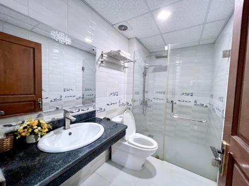 a white bathroom with a sink and a toilet at Đức Thắng Hotel in Sầm Sơn