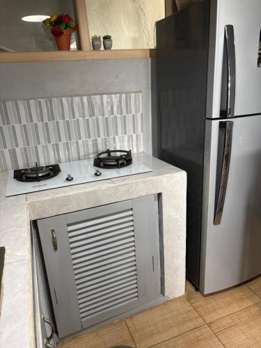 a kitchen with a stove and a refrigerator at villa Angin in Munggu
