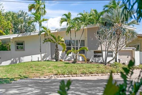 a house with palm trees in front of it at Waterfront Gem , private boat dock , ocean access in Fort Lauderdale