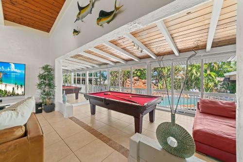 a pool table in a living room with a pool table at Waterfront Gem , private boat dock , ocean access in Fort Lauderdale