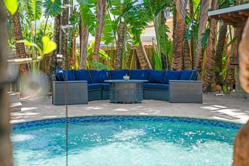 a blue couch sitting next to a swimming pool at Waterfront Gem , private boat dock , ocean access in Fort Lauderdale