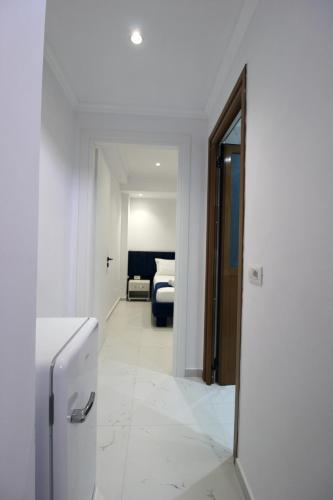 a white room with a hallway with a refrigerator at Garden Vila Ermali in Ksamil