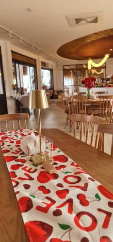 a table with a table cloth with red flowers on it at โรงแรม ริเวอร์บรีซ เชียงแสน River Breeze Chiangsean in Chiang Saen