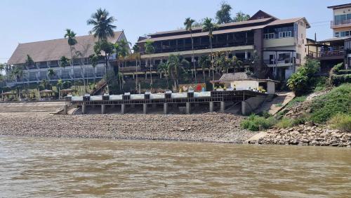 a building on the banks of a river at โรงแรม ริเวอร์บรีซ เชียงแสน River Breeze Chiangsean in Chiang Saen