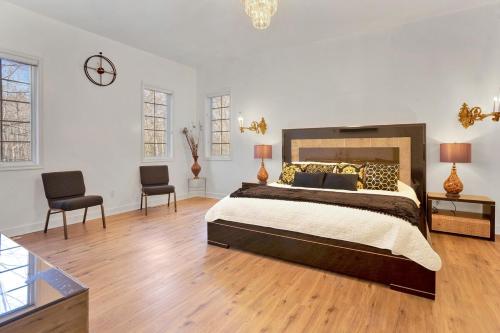 a large bedroom with a large bed and two chairs at Fancy Poconos Castle Indoor MEGA 10plus Hot Tub in East Stroudsburg