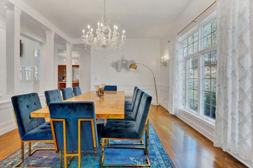 a dining room with a wooden table and blue chairs at Fancy Poconos Castle Indoor MEGA 10plus Hot Tub in East Stroudsburg