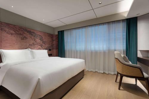 a bedroom with a large bed and a window at Wingate by Wyndham Yunfu Xinxing in Yunfu