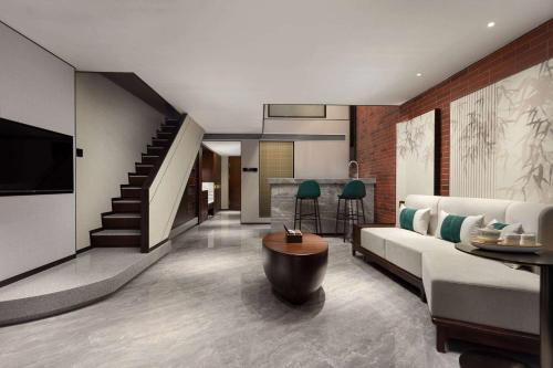a living room with a couch and a kitchen at Wingate by Wyndham Yunfu Xinxing in Yunfu