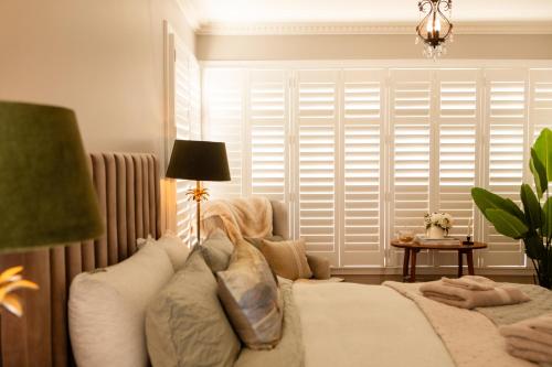 a bedroom with a bed and a window with shutters at 'The Light-House' Entire Home with Coastal Views in Devonport