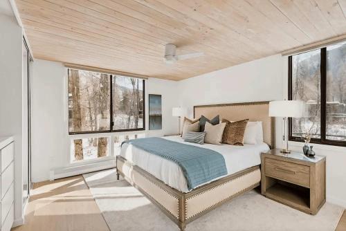 una camera da letto con un letto grande e finestre di Renovated Riverfront 3 BR, 2 BA with Pool - Walk to Town! ad Aspen