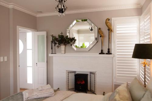 a living room with a fireplace and a mirror at 'The Light-House' Entire Home with Coastal Views in Devonport