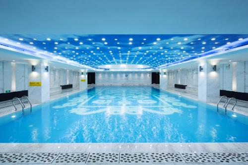a large indoor pool with lights on the ceiling at Millennium Hotel Fuqing in Rongcheng