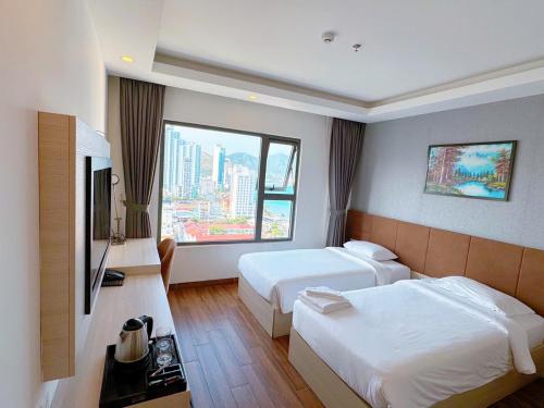 a hotel room with two beds and a large window at Putin Hotel Nha Trang in Nha Trang